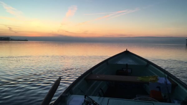 Blick aus einem Angelboot über den Bodensee bei Sonnenaufgang