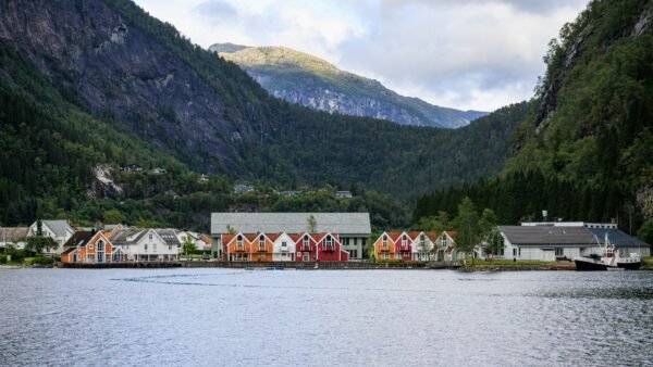 Norwegisches Angelcamp an einem Fjord mit Bergen im Hintergrund – typische Unterkunft für einen Angelurlaub in Norwegen.