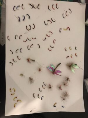 Verschiedene gebundene Fliegen und Nymphen für das Fliegenfischen auf einer Unterlage