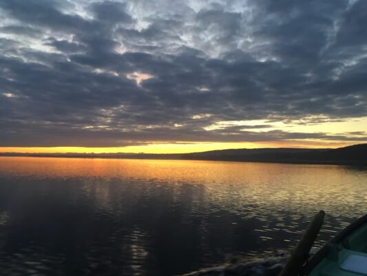 Großer See bei Sonnenuntergang vom Angelboot aus gesehen