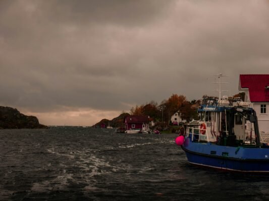 Stürmisches Wetter in einem norwegischen Hafen zeigt, warum Wetter und Sicherheit beim Angeln in Norwegen besonders wichtig sind.