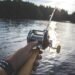 Angler hält eine Bootsrute mit Multirolle über dem Wasser