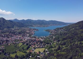 Luftaufnahme des Tegernsees mit Rottach-Egern und den bewaldeten Bergen