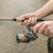 Angler hält eine Rute mit bespulter Rolle am Wasser und testet eine Karpfenschnur